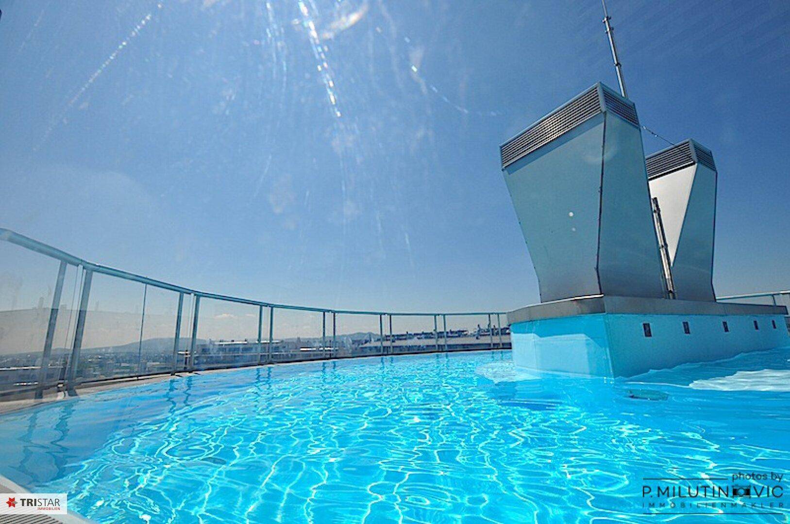 Dachterrasse mit großem Pool und weitem Blick über die Stadt.