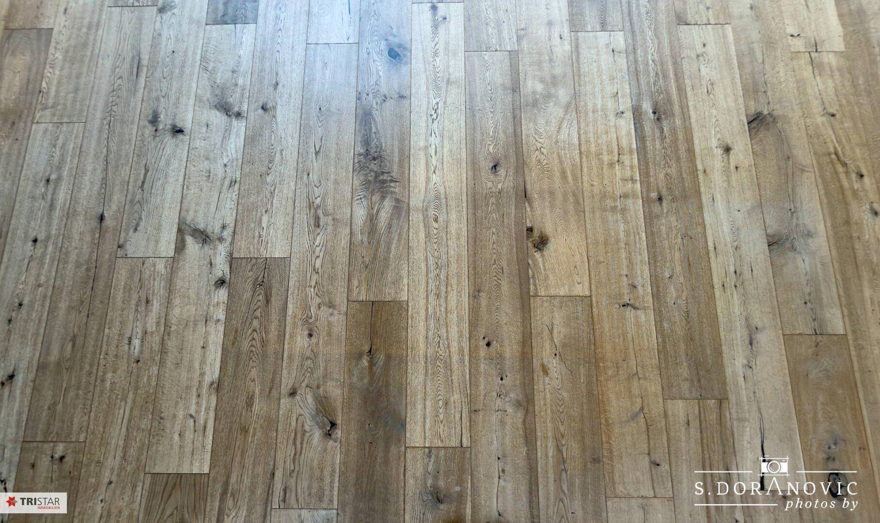 Detailaufnahme eines robusten Holzbodens mit natürlicher Maserung und Struktur.