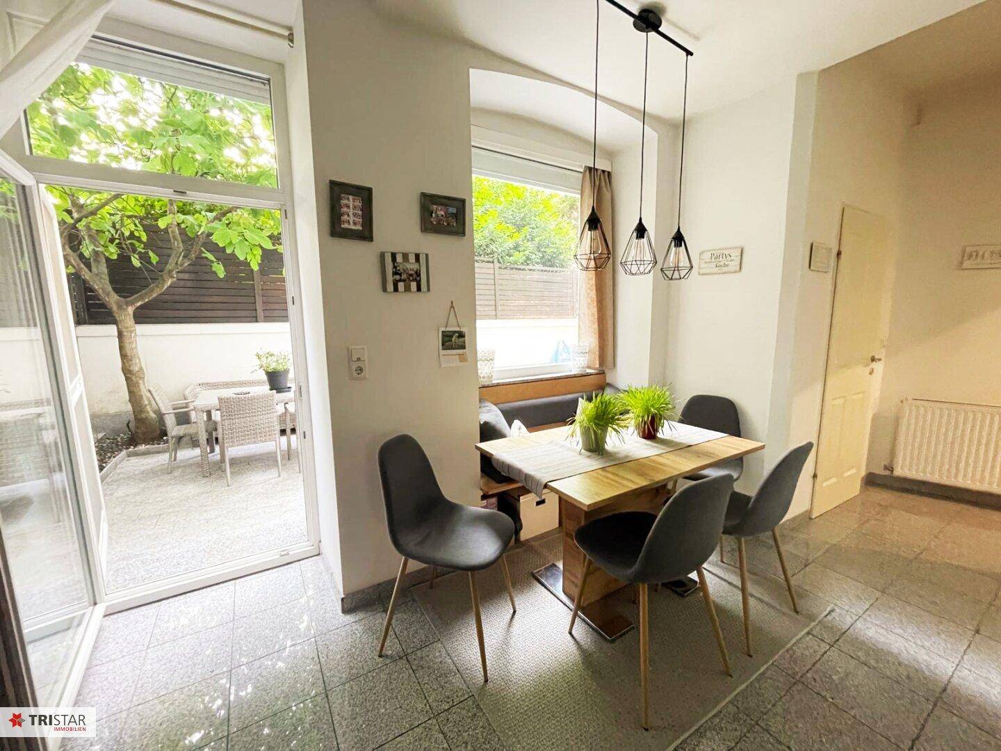Heller Essbereich mit Holztisch, modernen Stühlen und direktem Zugang zur Terrasse.