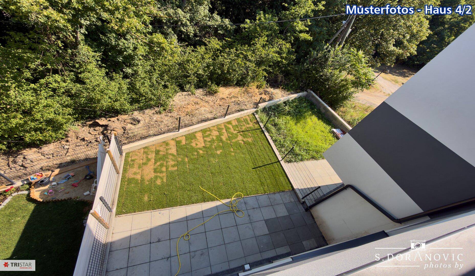 Vogelperspektive auf die Terrasse und den Gartenbereich des modernen Hauses.