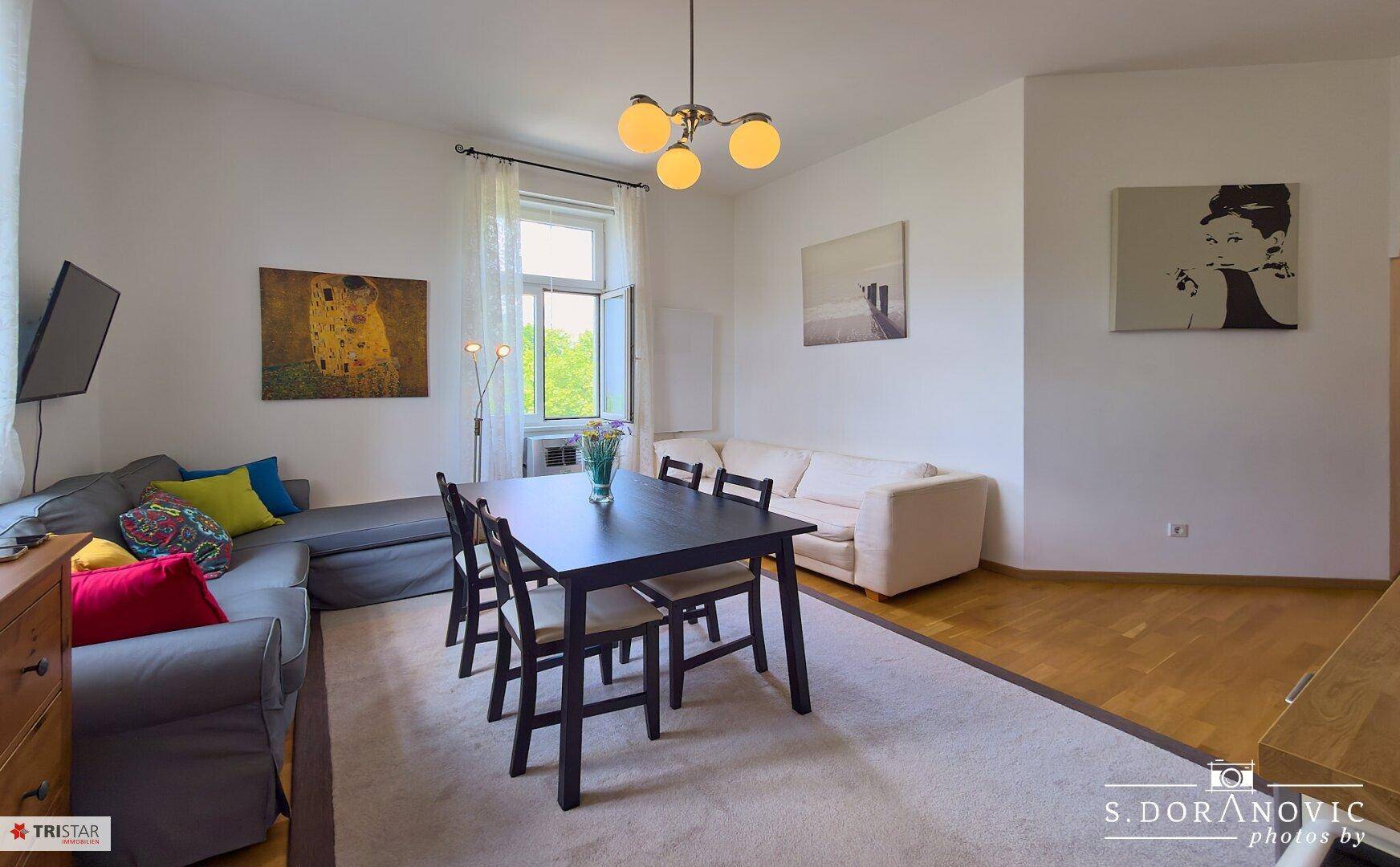 Geräumiger Wohn- und Essbereich mit bequemen Sofas, Esstisch und Holzboden.
