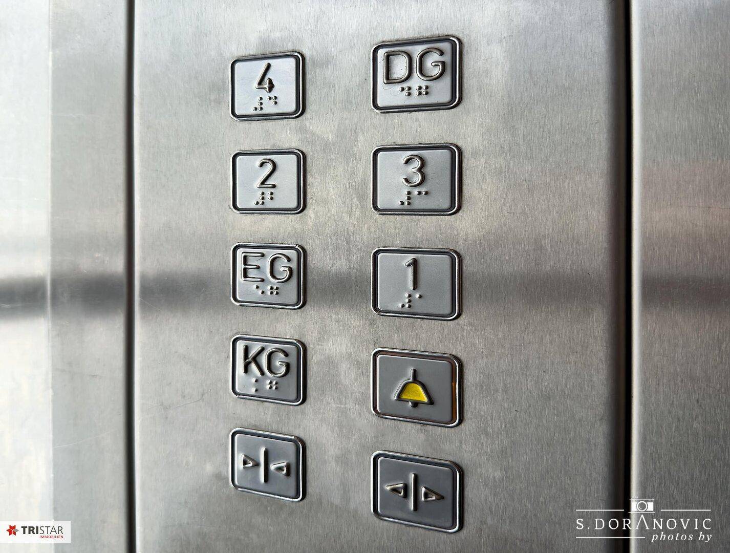 Aufzugsknöpfe mit Braille-Beschriftung für verschiedene Stockwerke im Gebäude.