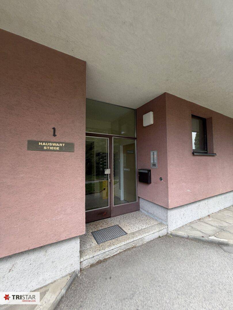 Detaillierter Eingangsbereich eines Wohnhauses mit Klingeln und Briefkästen, einladend gestaltet.