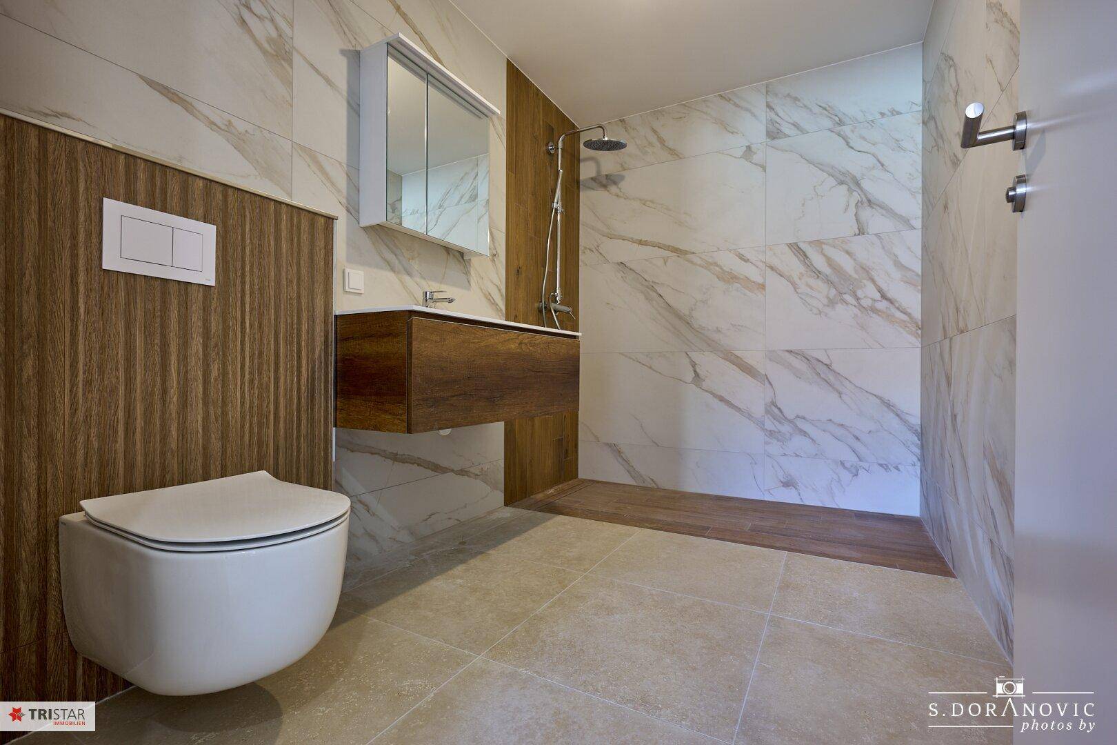 Modernes Badezimmer mit begehbarer Dusche, Wand-WC und eleganten Marmorfliesen.