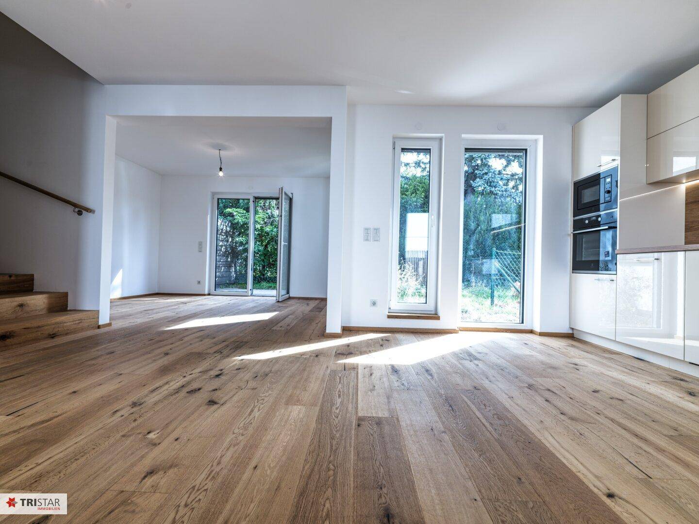 Geräumiger Wohnbereich mit offener Küche, Eichenparkett und Treppe zum Obergeschoss.