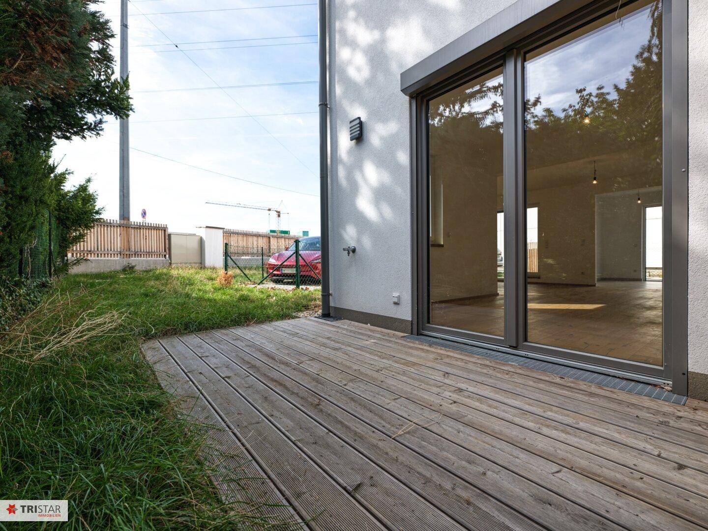 Holzterrasse am Haus mit Blick auf den Garten und die Umgebung.