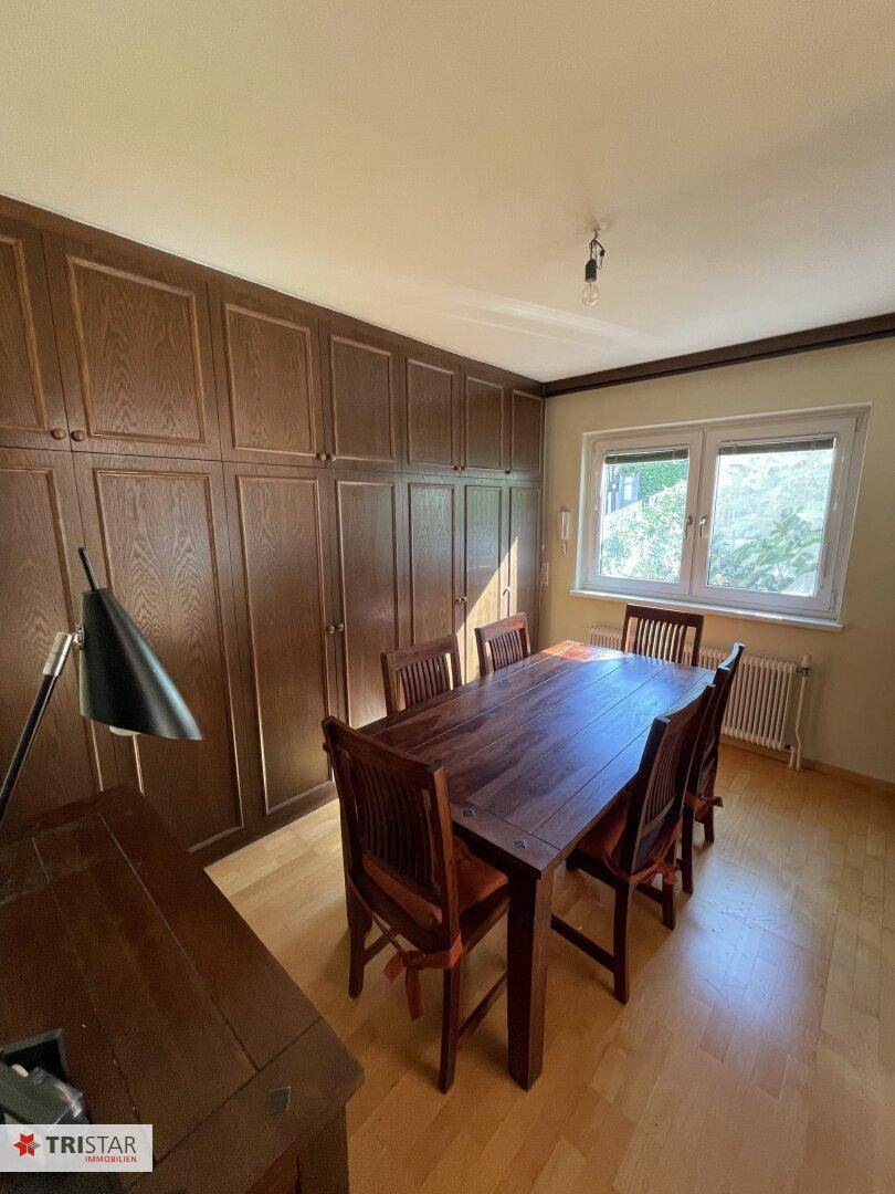 Geräumiges Esszimmer mit großem Holztisch, Stühlen und Einbauschränken.