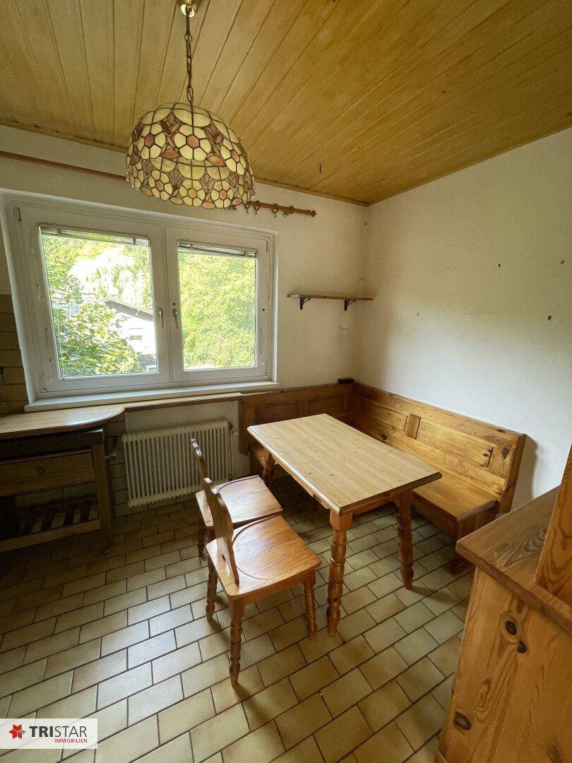 Gemütliche Wohnküche mit traditioneller Eckbank, Holztisch und Stühlen.