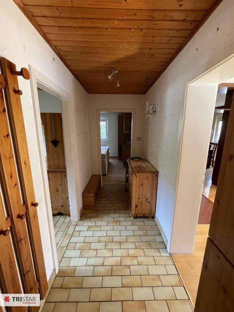 Eingangsbereich mit Holzdecke, Fliesenboden und Garderobe.