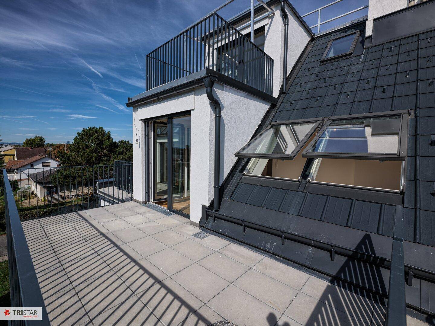 Geräumige Dachterrasse mit Blick auf die Umgebung und moderne Dachfenster.
