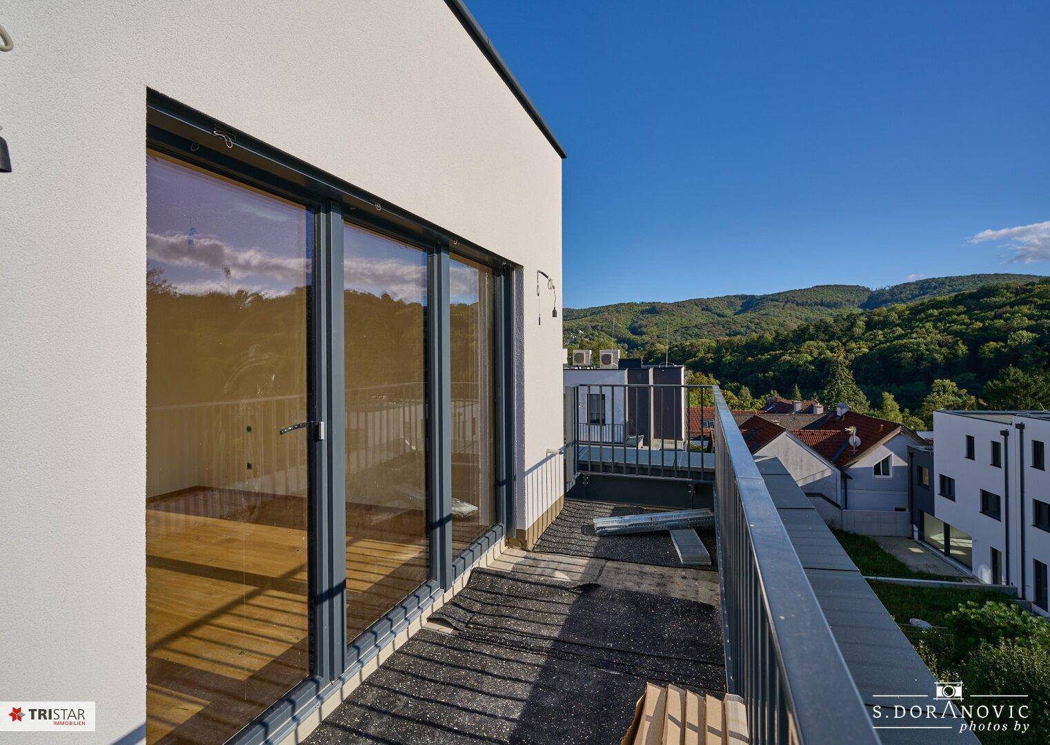 Balkon mit Metallgeländer und weitem Blick auf die umliegende Hügellandschaft.