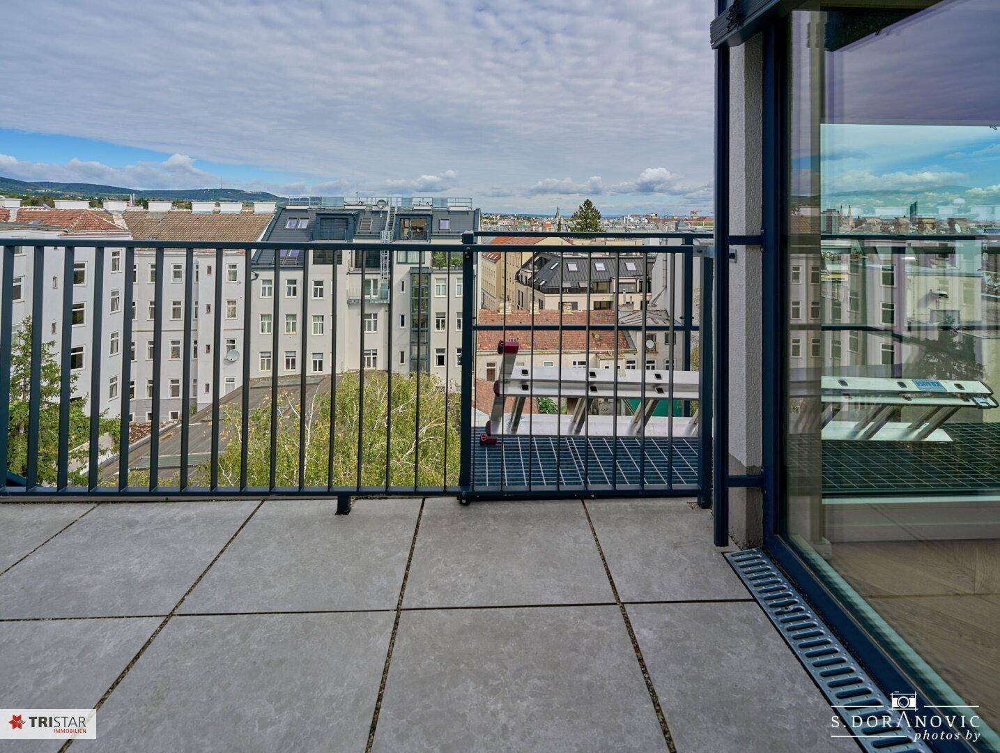Dachterrasse mit Blick auf die Stadt und umliegende Gebäude, ideal für Outdoor-Aktivitäten.