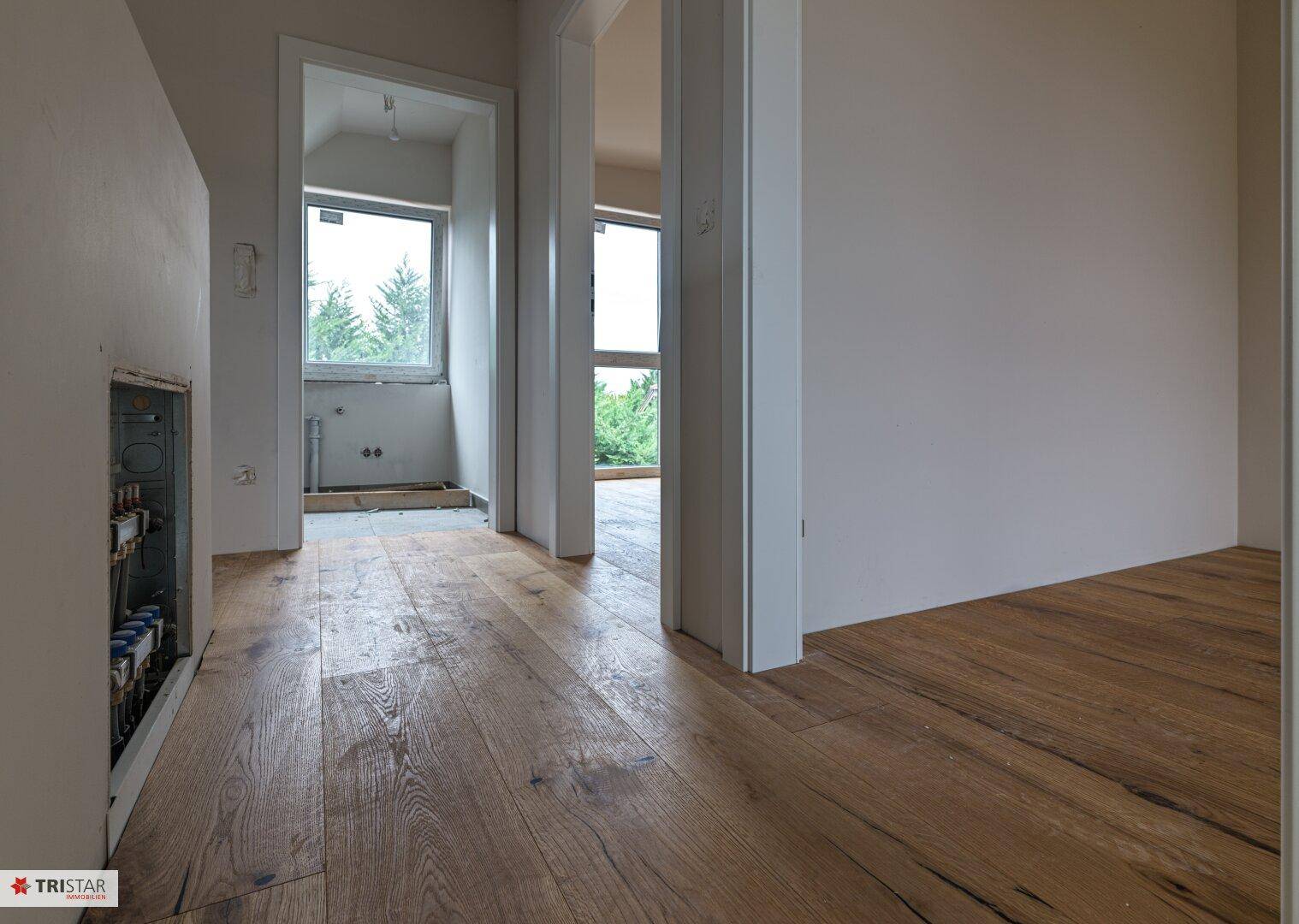 Heller Flur mit Holzboden und mehreren Türen, die zu verschiedenen Räumen führen.