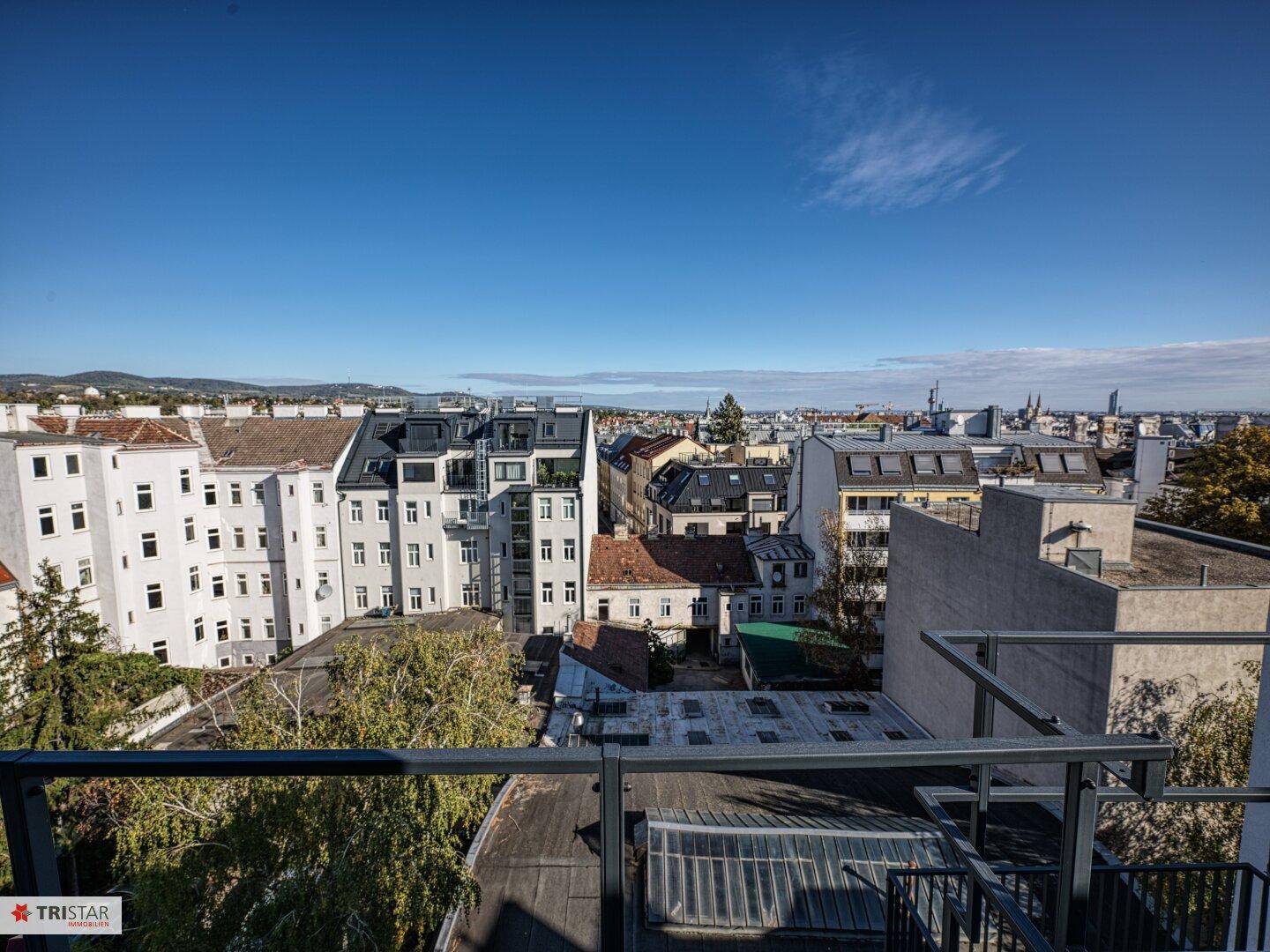 Panoramablick über die Stadt mit verschiedenen Gebäuden und einem klaren blauen Himmel.