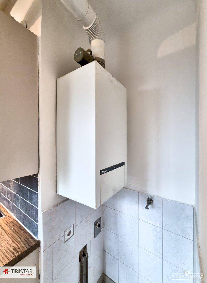 Gastherme an der Wand in einem gefliesten Bereich, zuständig für Warmwasser und Heizung.