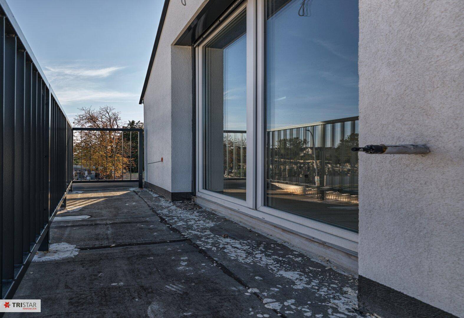Geräumiger Balkon im Obergeschoss mit Metallgeländer und Blick auf die Umgebung.