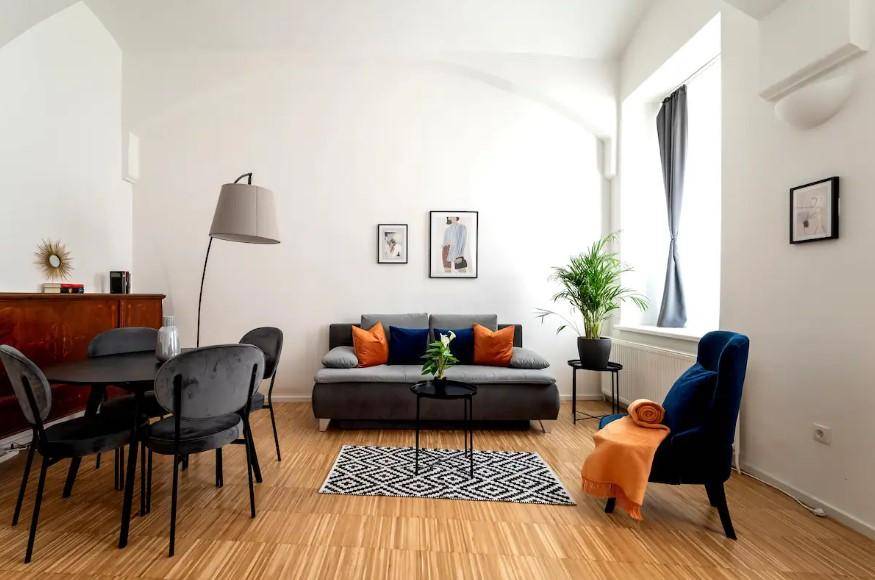 Kombinierter Wohn- und Essbereich mit modernem Sofa, Esstisch und farbigen Akzenten.