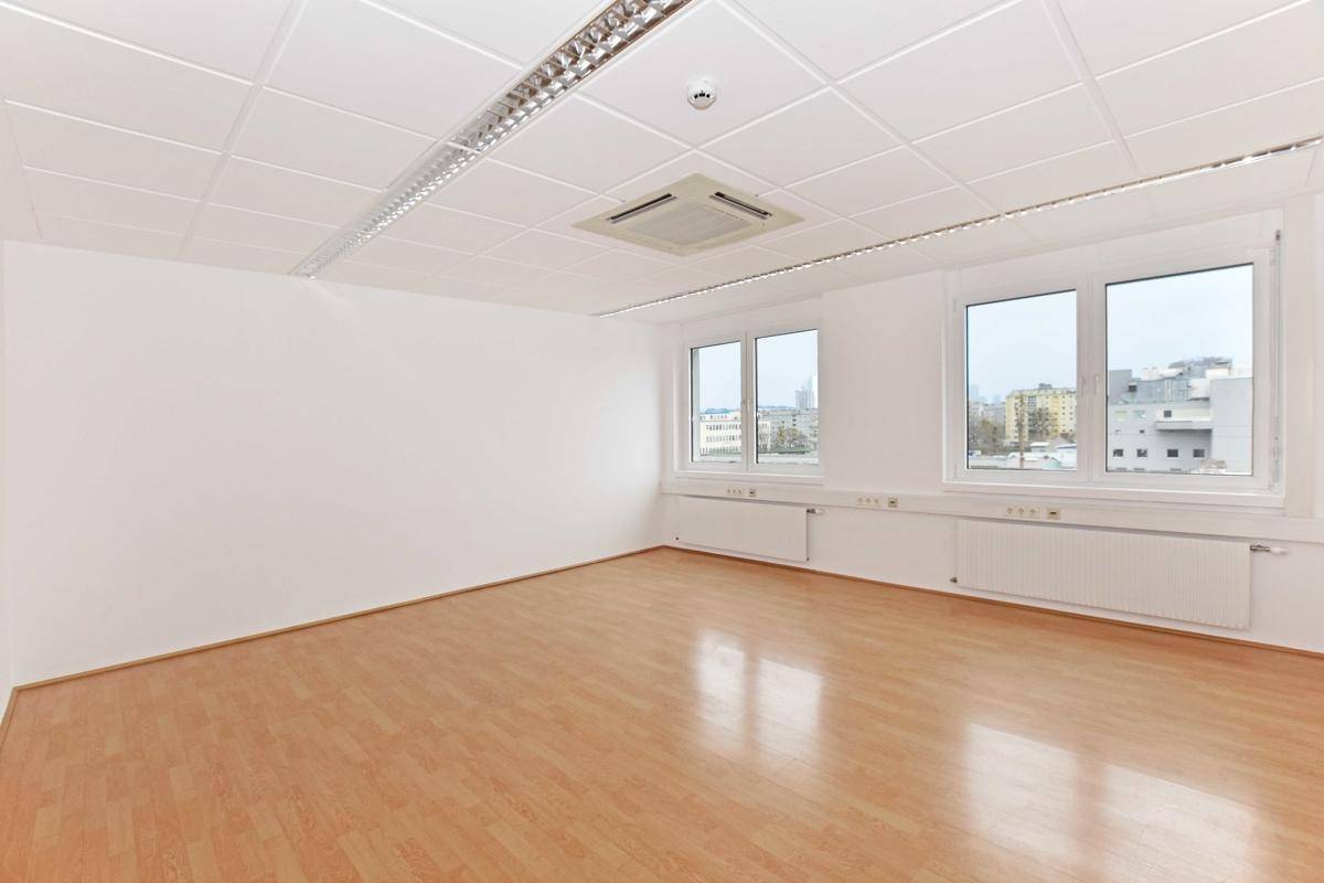 Geräumiges und helles Büro mit großen Fenstern und Blick auf die Stadt, ausgestattet mit Klimaanlage.