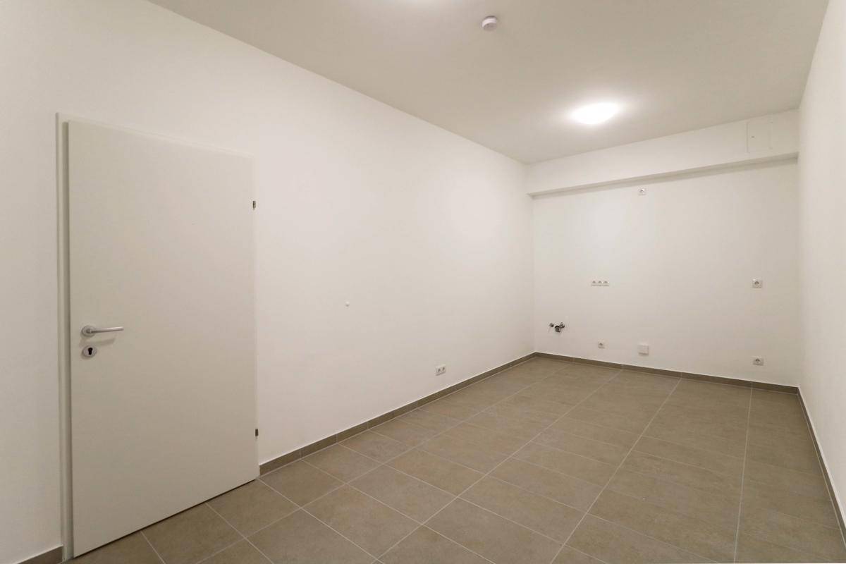 Kleiner, gefliester Raum mit weißen Wänden und Anschlüssen, ideal als Abstell- oder Technikraum.