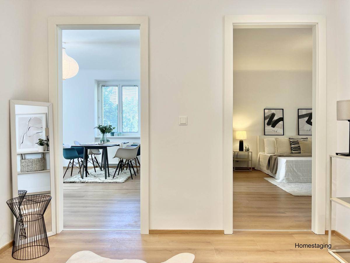 Heller Flur mit Blick in das Wohnzimmer und ein weiteres Schlafzimmer.