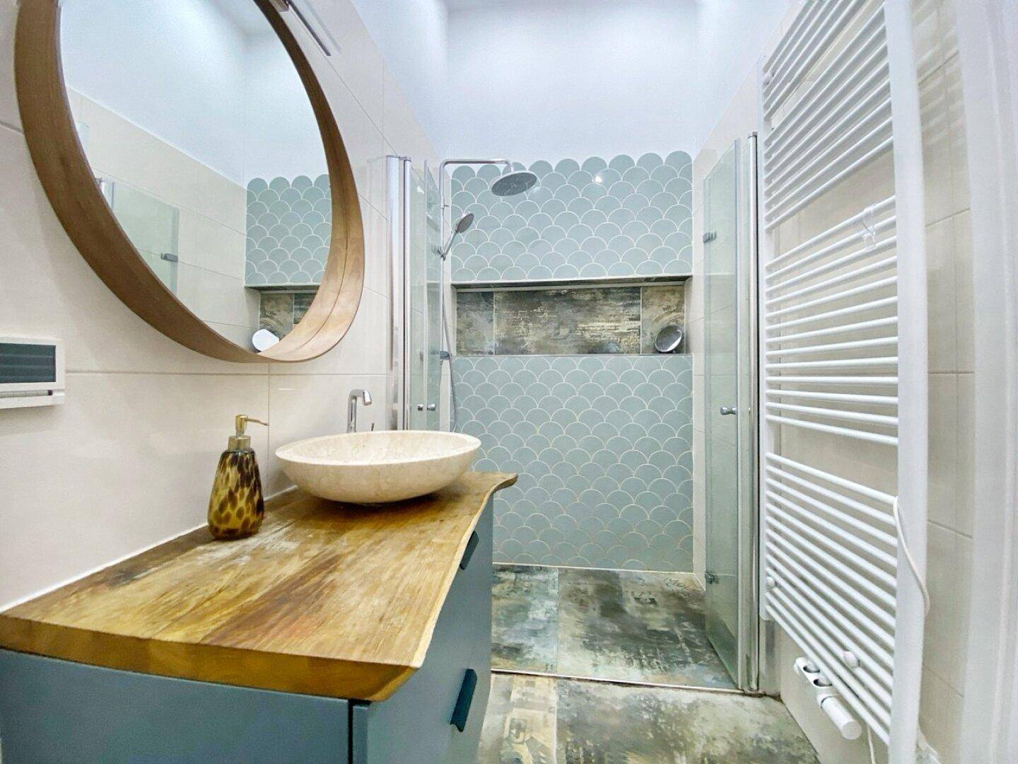 Modernes Badezimmer mit begehbarer Dusche, Holzwaschtisch und beheiztem Handtuchhalter.