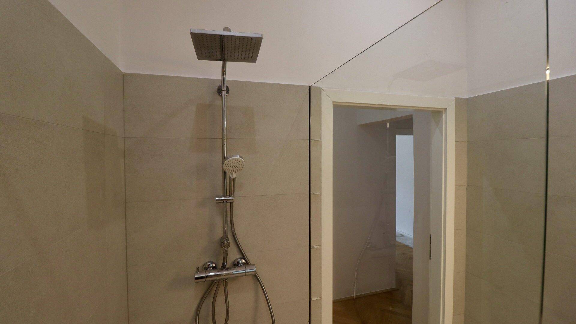 Geräumige Duschkabine mit moderner Regendusche und klaren Glaswänden.