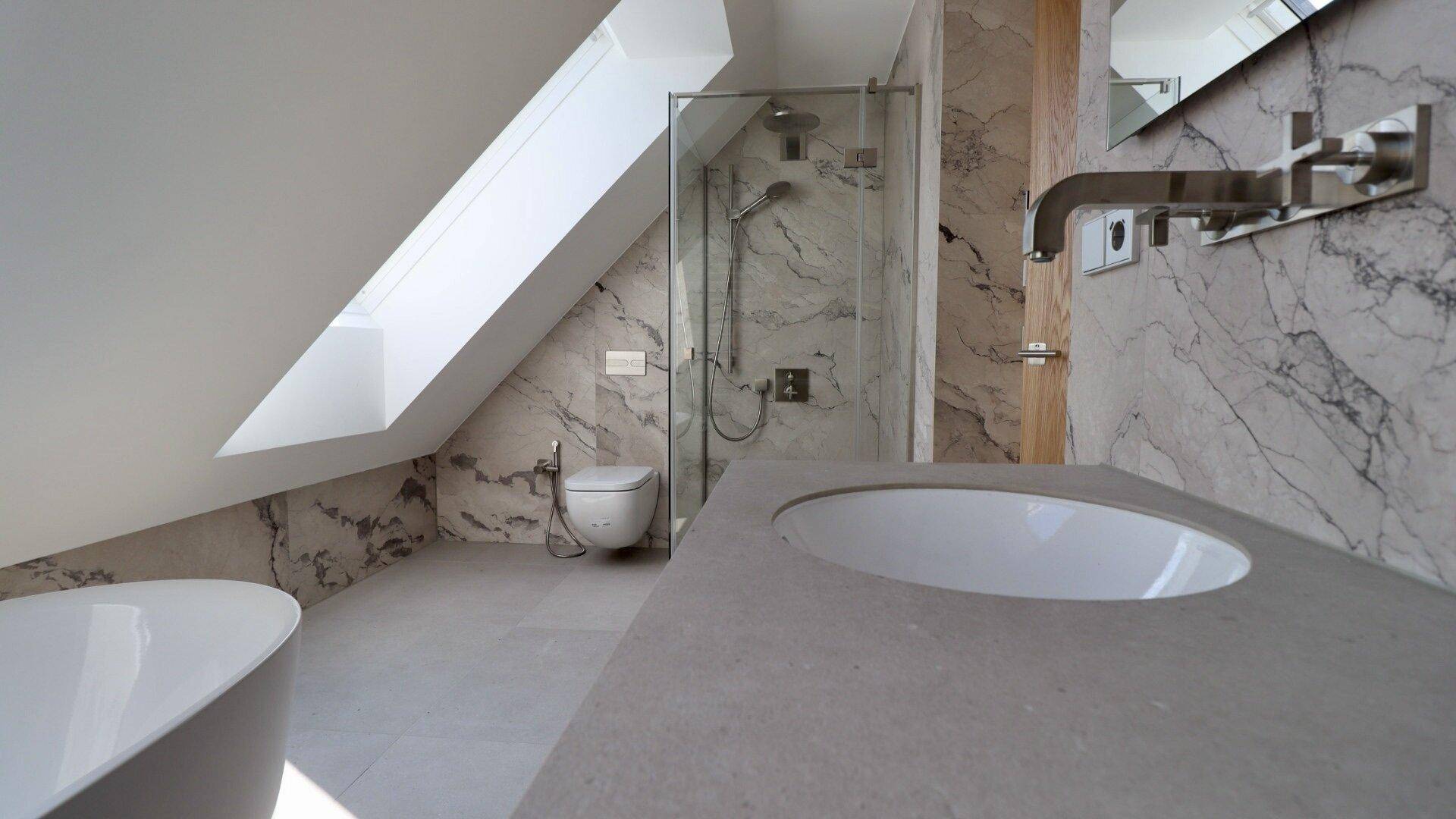 Elegantes Badezimmer mit begehbarer Dusche, Wand-WC, Marmorfliesen und Dachschräge.