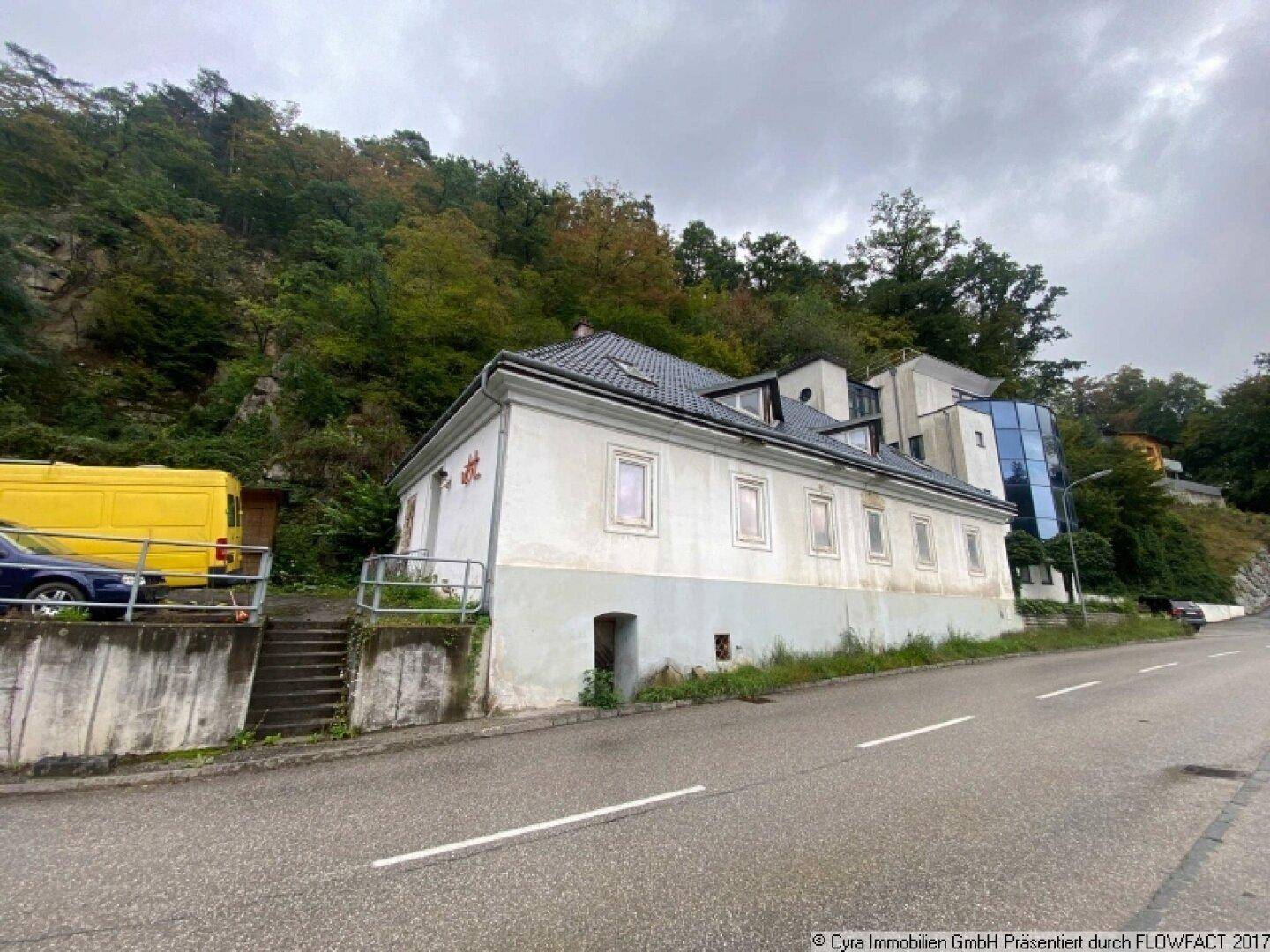 Straßenansicht des älteren Gebäudeteils mit traditioneller Architektur und sichtbaren Gebrauchsspuren.