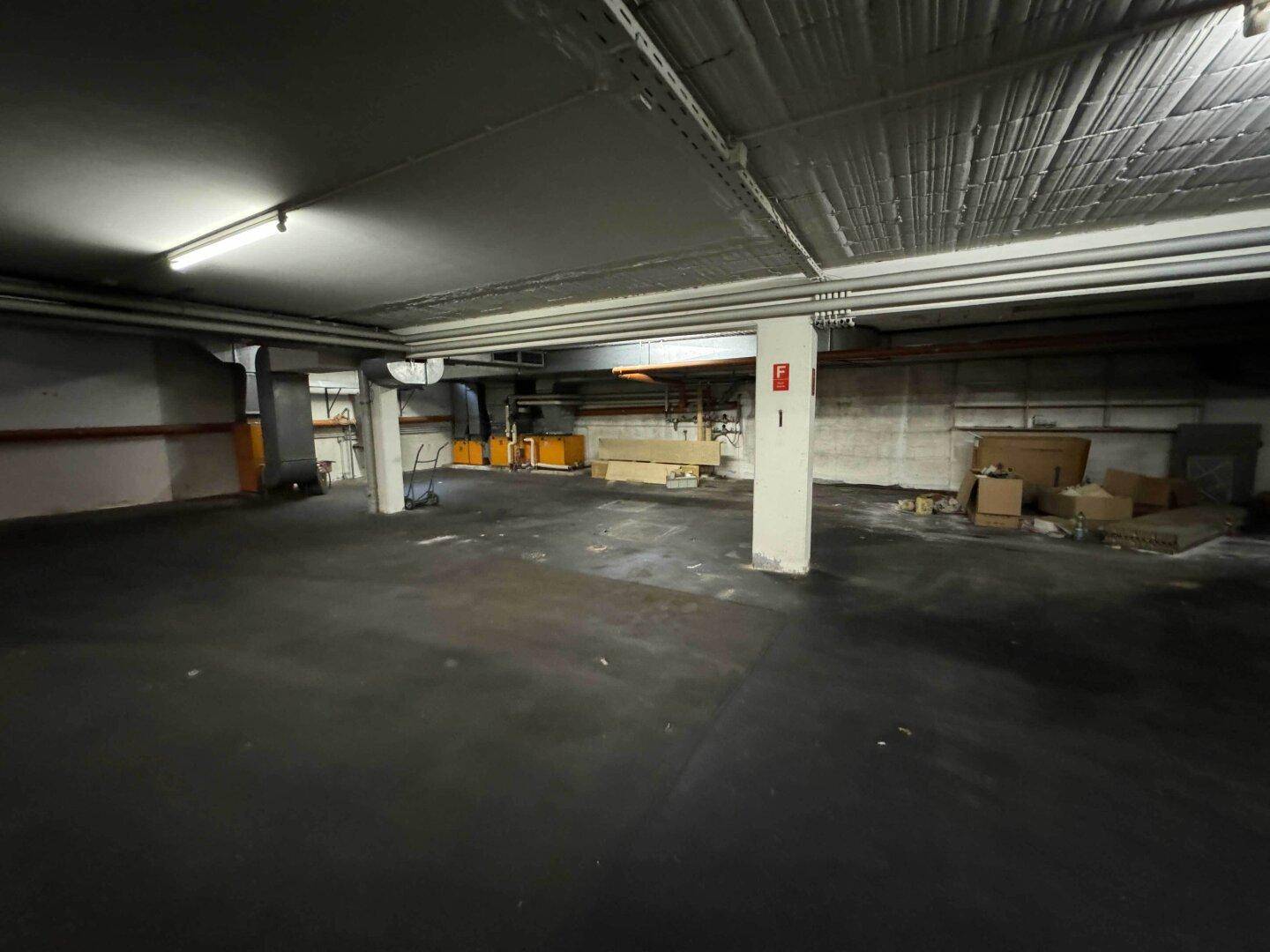 Geräumige Tiefgarage mit Betonboden und Lagerflächen.