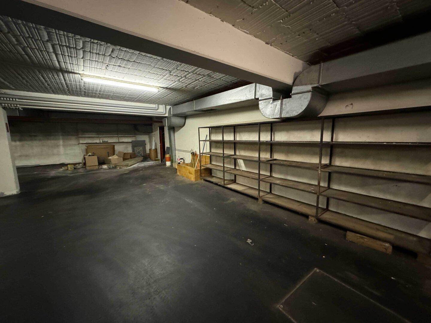 Tiefgarage mit Regalen für Lagerung und Betonboden.