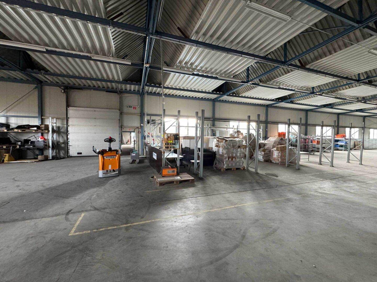 Lagerhalle mit Gabelstapler, Regalen und verpackten Waren, bereit für den Betrieb.