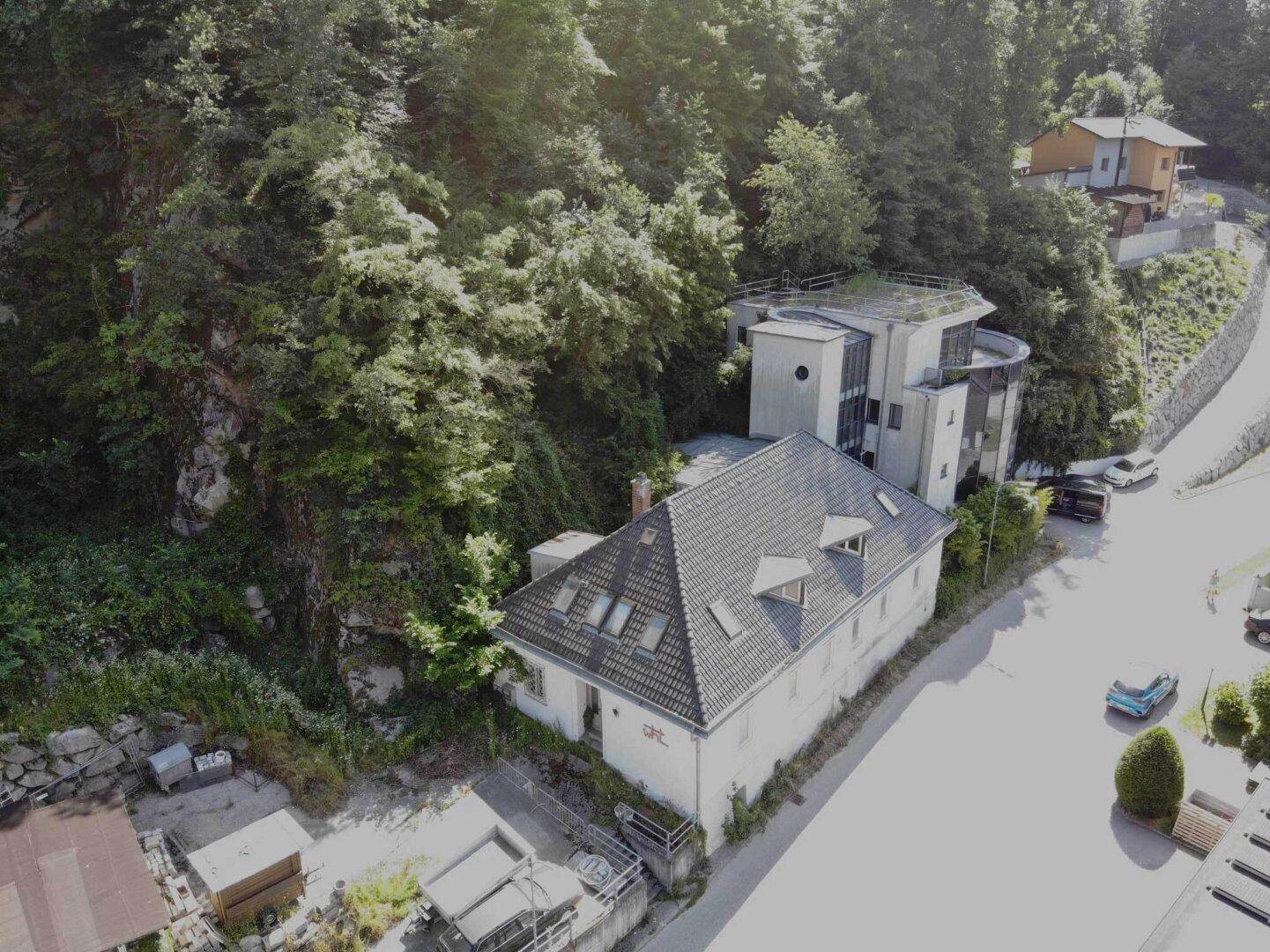 Luftaufnahme des Anwesens, eingebettet in einen bewaldeten Hang mit dichter Vegetation.