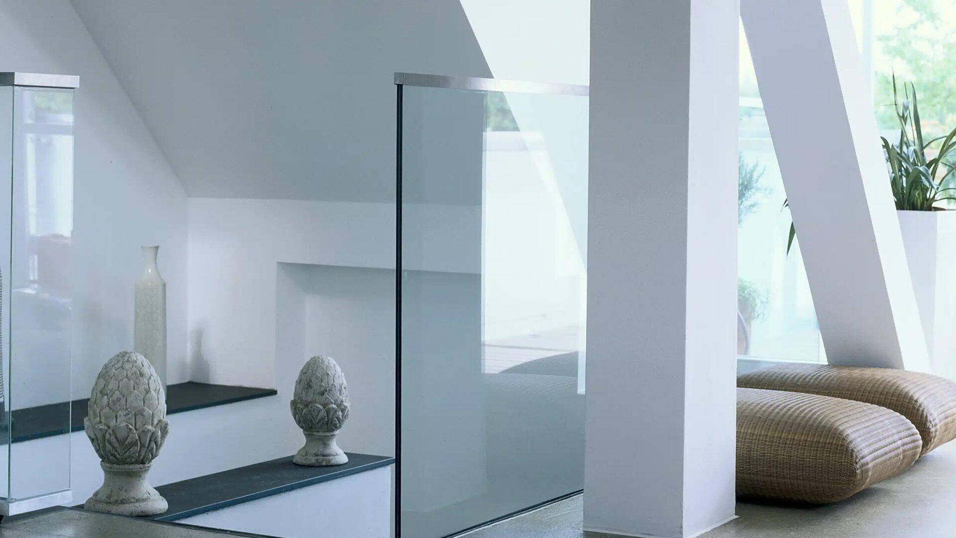 Heller Flurbereich mit modernen Glasgeländern und dekorativen Elementen.