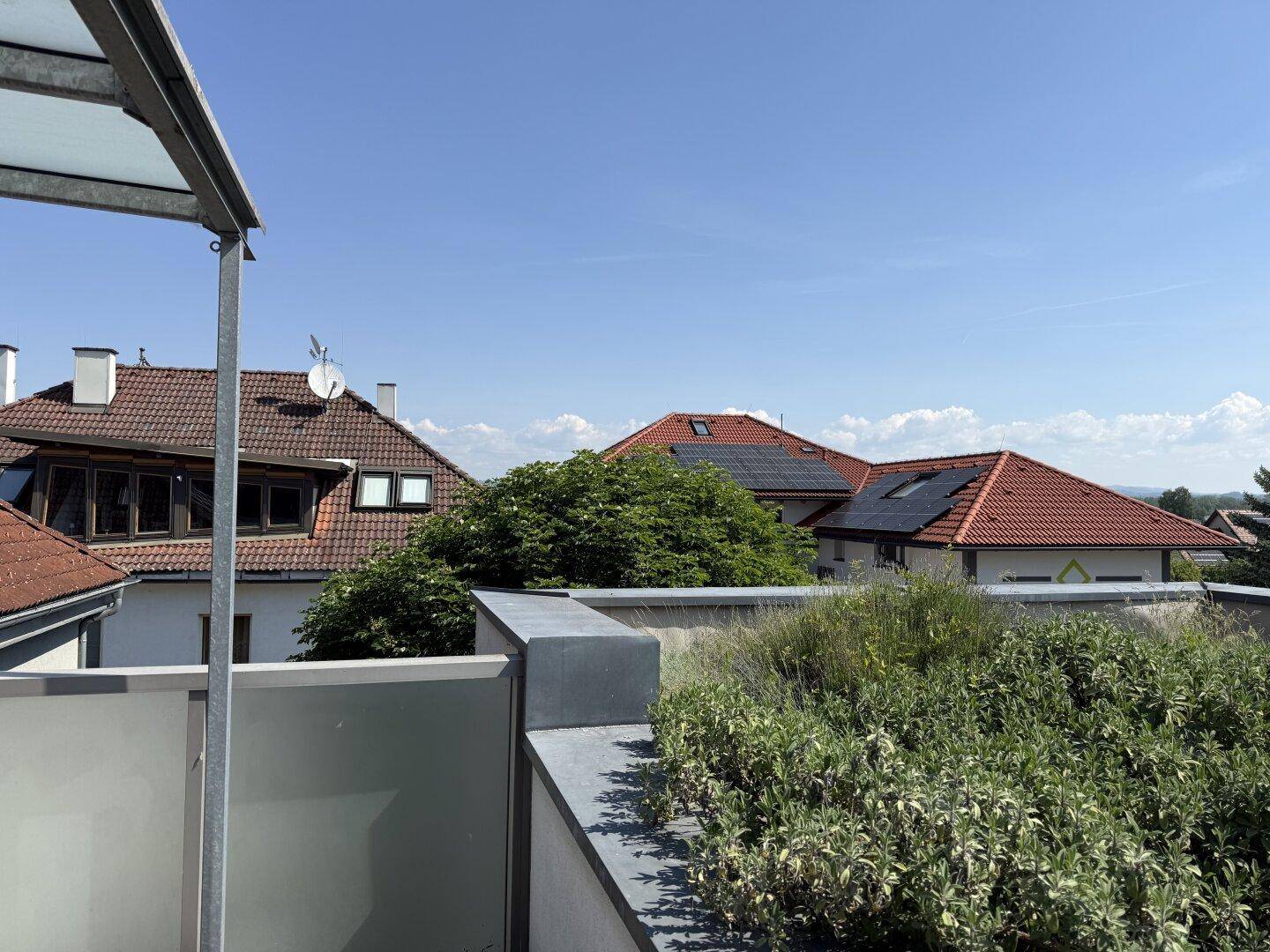 Panoramablick von der Dachterrasse auf die umliegende Wohnbebauung mit Solaranlagen.