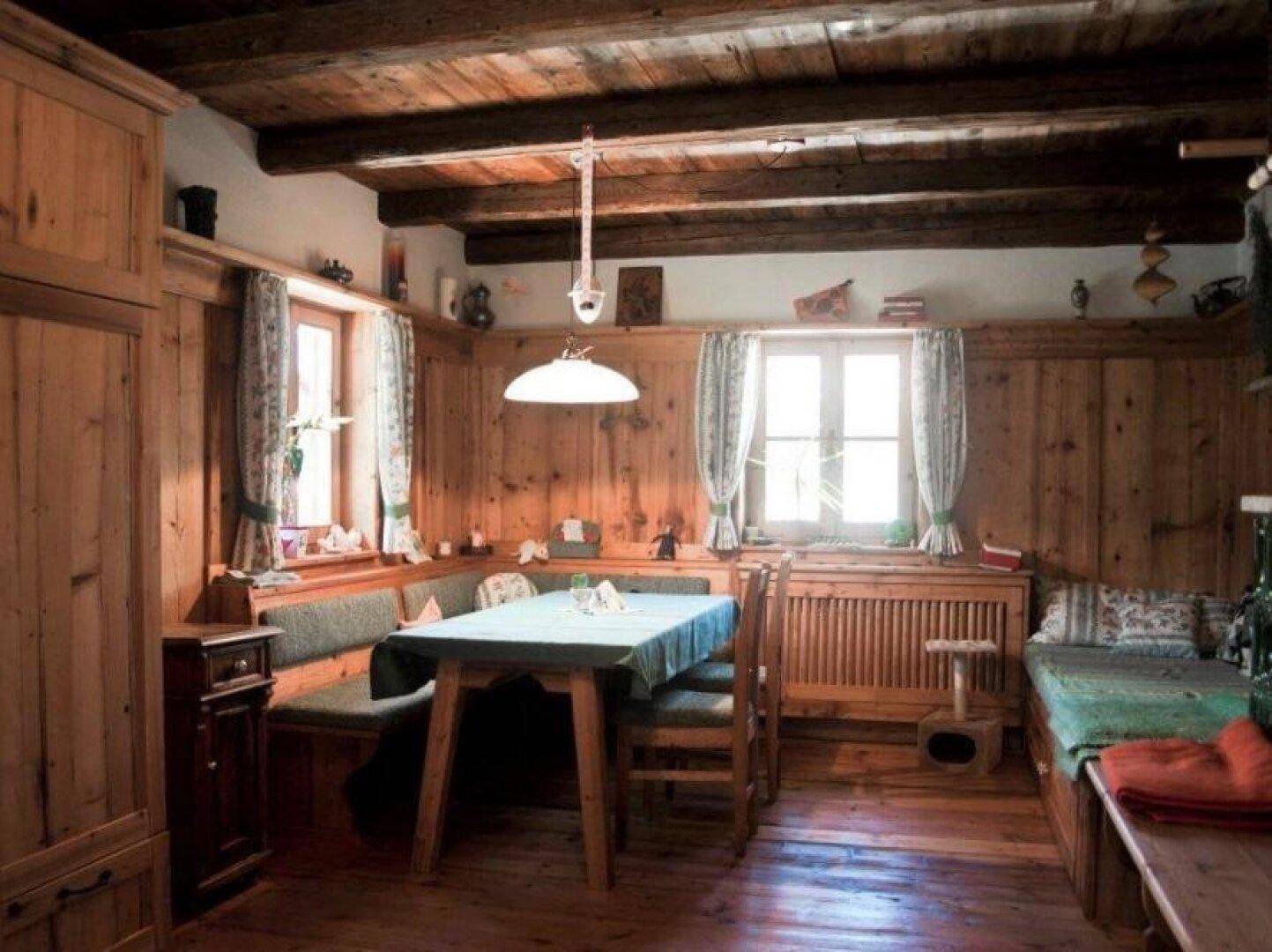 Rustikaler Essbereich mit Holztäfelung, eingebauter Sitzbank und traditionellem Holztisch.