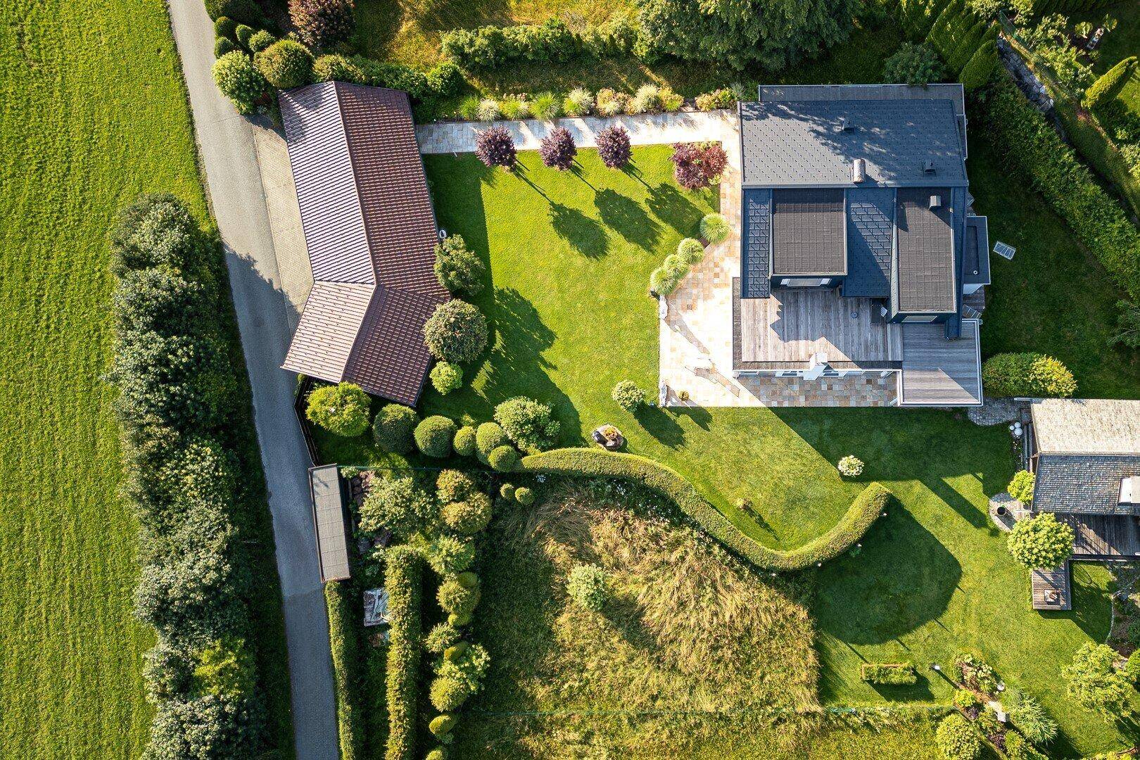 Vogelperspektive des Anwesens mit weitläufigem Garten, großer Terrasse und Zufahrt zum Carport.