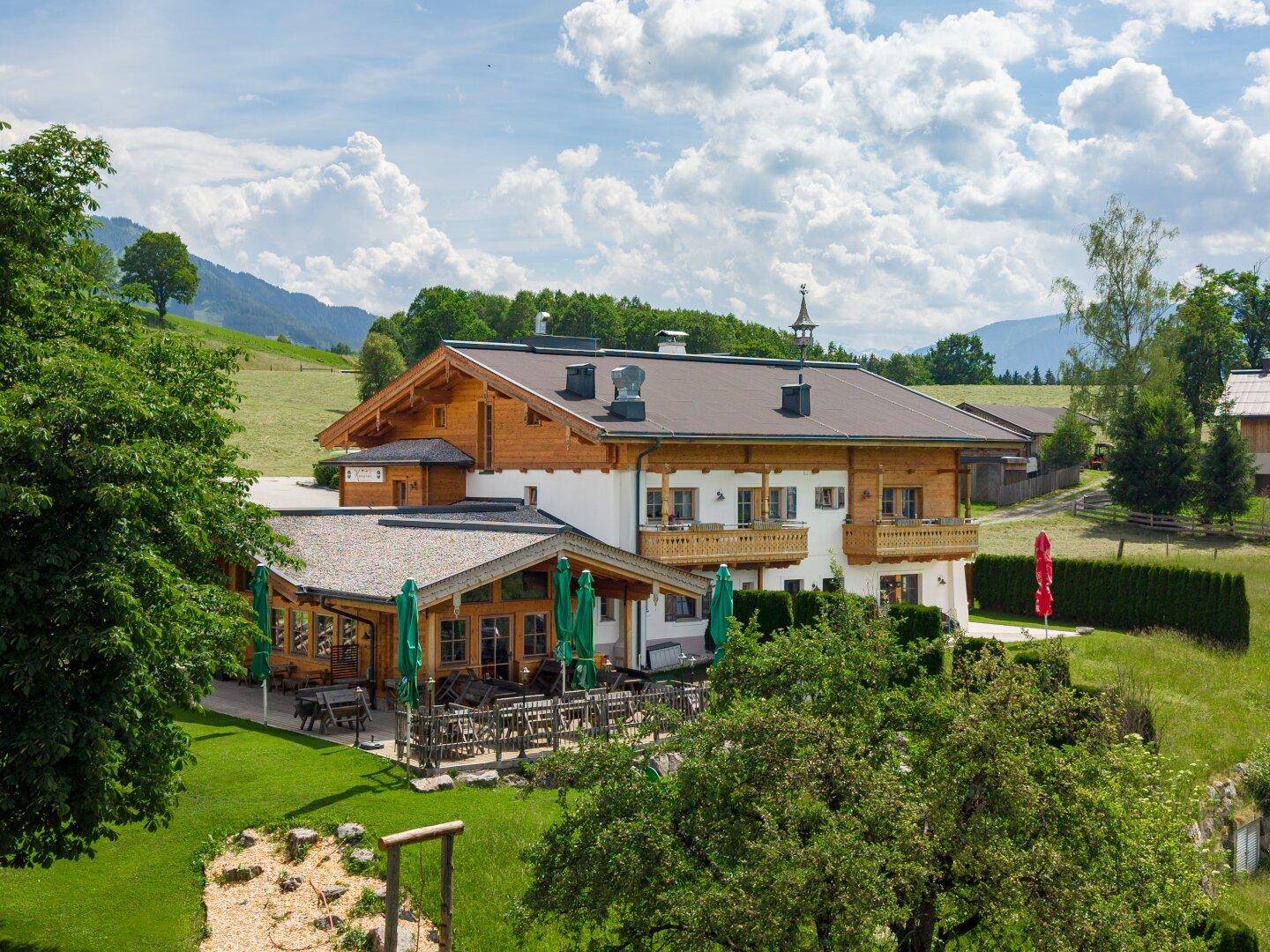Große Terrasse mit vielen Sitzgelegenheiten und Blick auf die umliegende Natur.