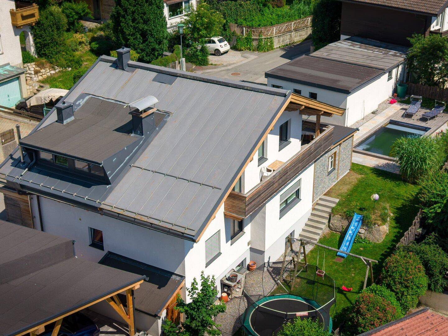Luftaufnahme des Hauses mit Garten, Pool und umliegender Nachbarschaft, eingebettet in die Landschaft.