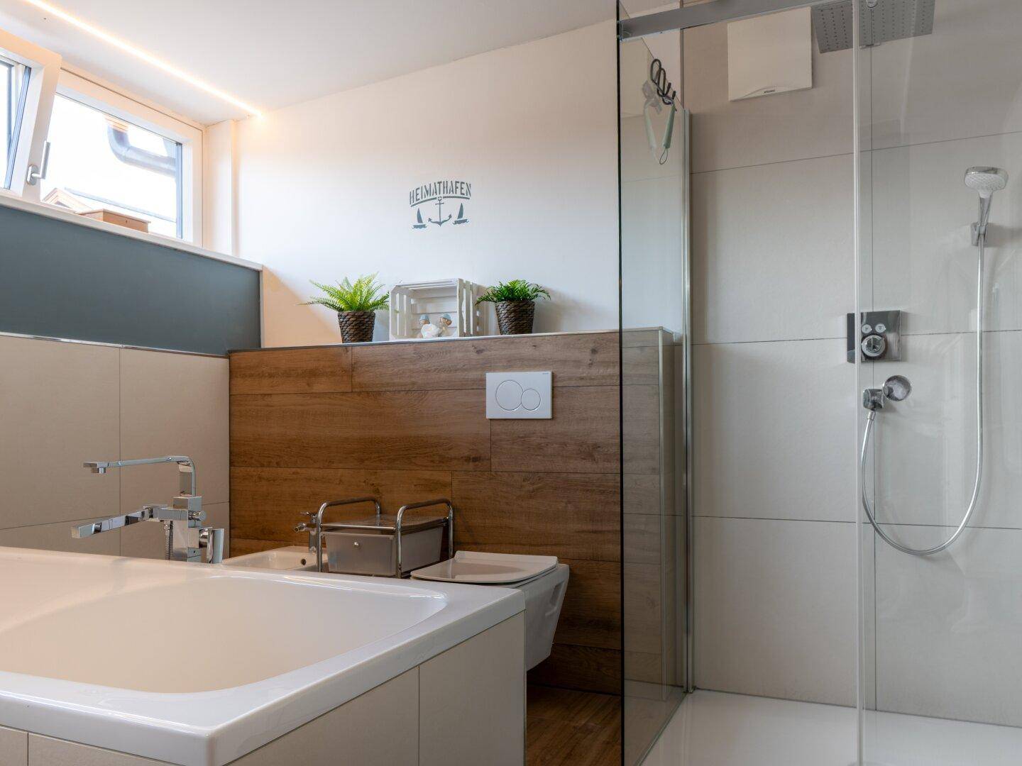 Helles Badezimmer mit begehbarer Dusche, Wand-WC und modernen Fliesen, funktional und stilvoll.