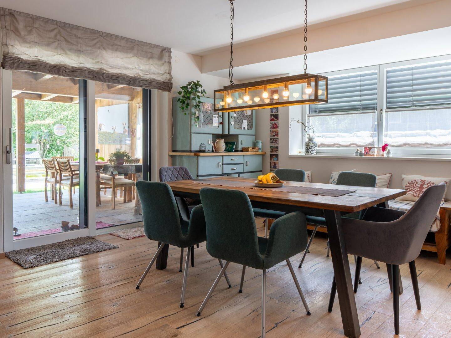 Heller Essbereich mit Holzboden und Zugang zur überdachten Terrasse, ideal für Familienmahlzeiten.