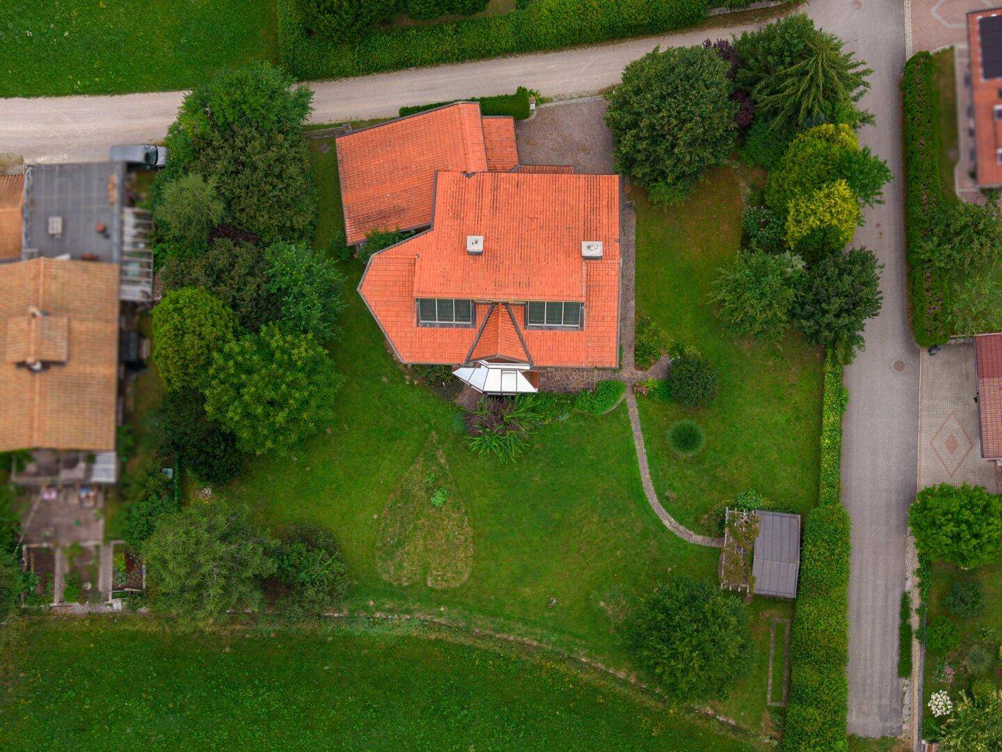 Luftaufnahme des Hauses mit großem Garten, Satteldach und umgebender Natur.