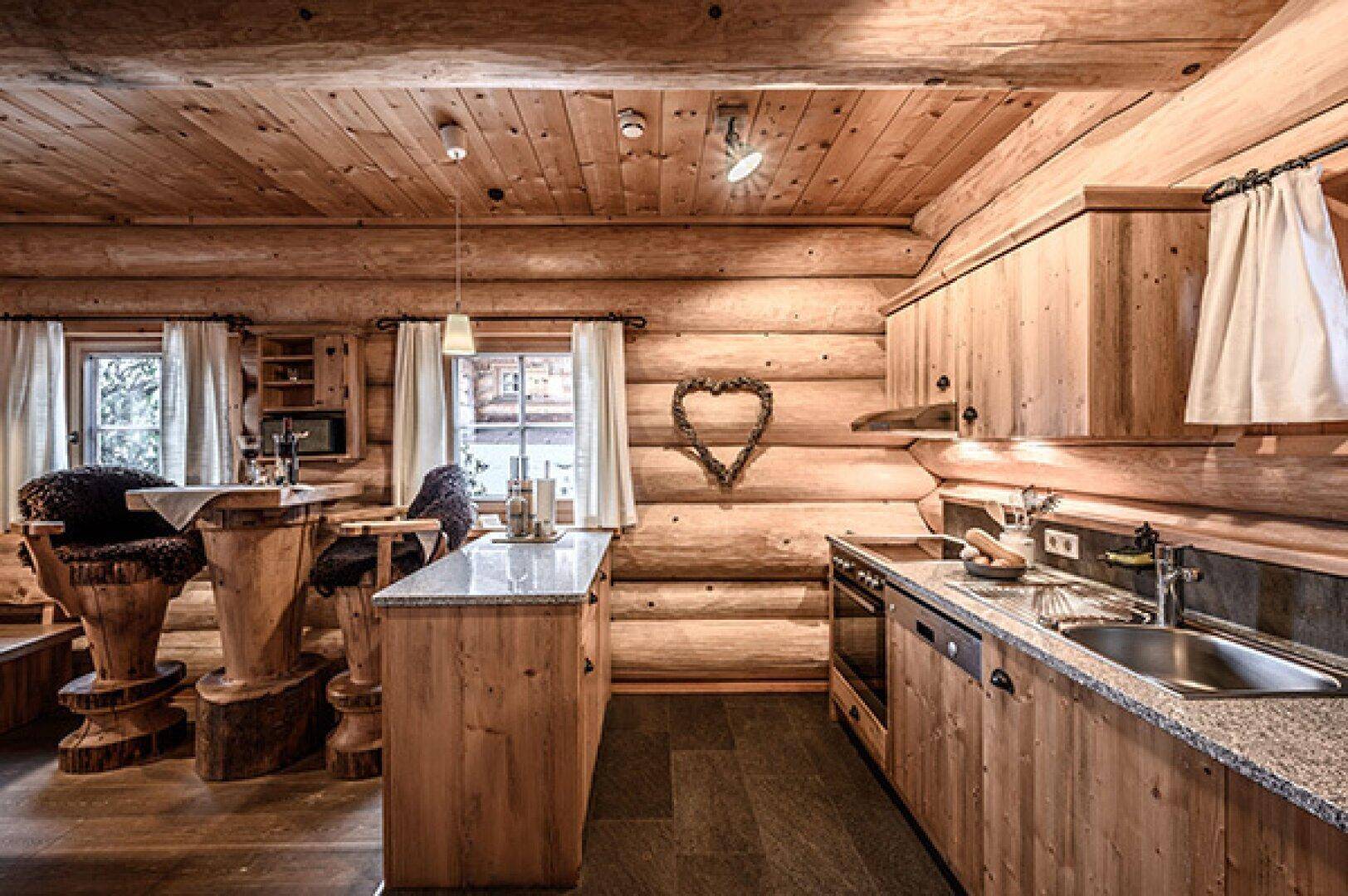 Rustikale Holzküche mit Granitarbeitsplatte, integrierten Geräten und Essbereich.