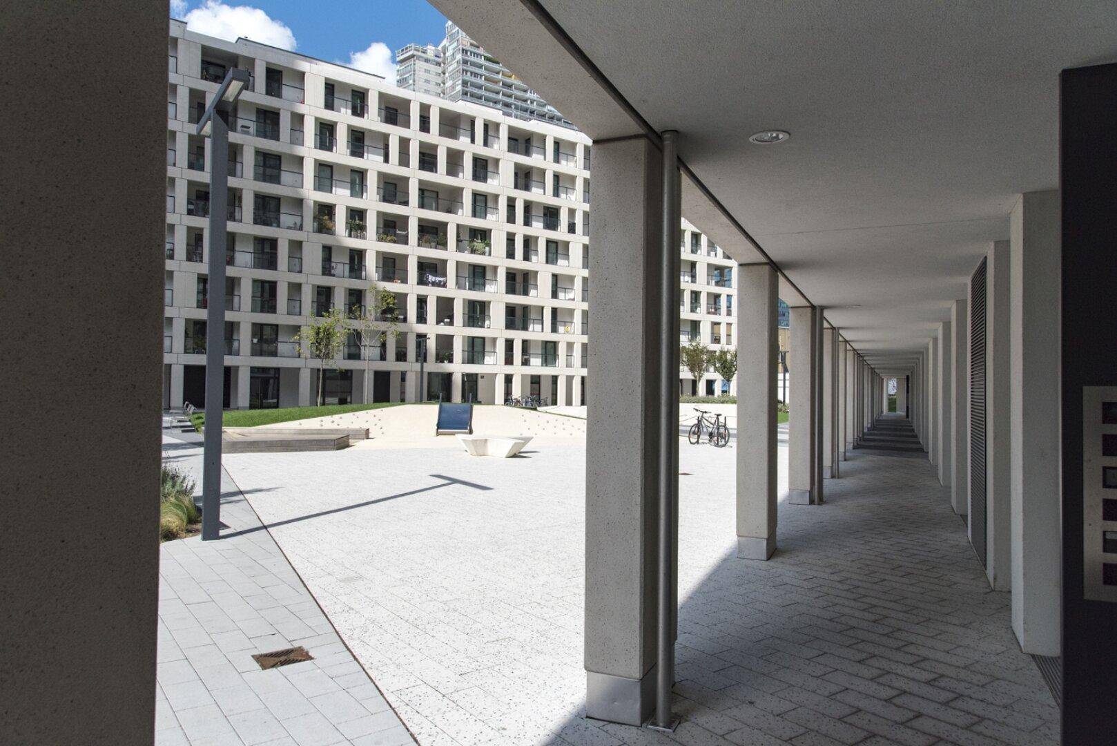 Moderne Wohngebäude mit klaren Linien und einem gepflasterten Innenhof, der zum Verweilen einlädt.