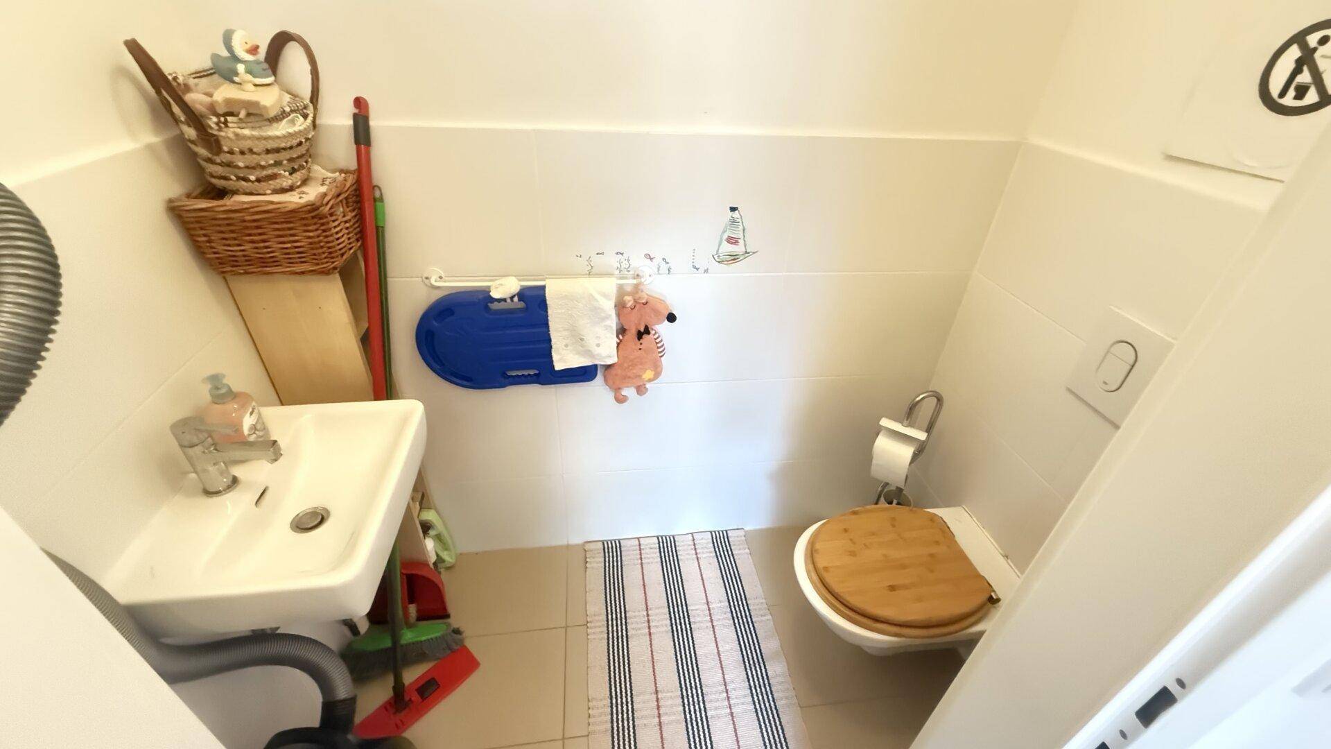 Gäste-WC mit kleinem Waschbecken und Toilette.