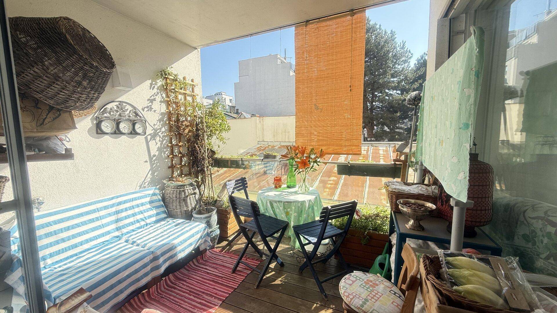 Gemütliche Terrasse mit Sitzgelegenheiten, Pflanzen und Blick auf die Umgebung.