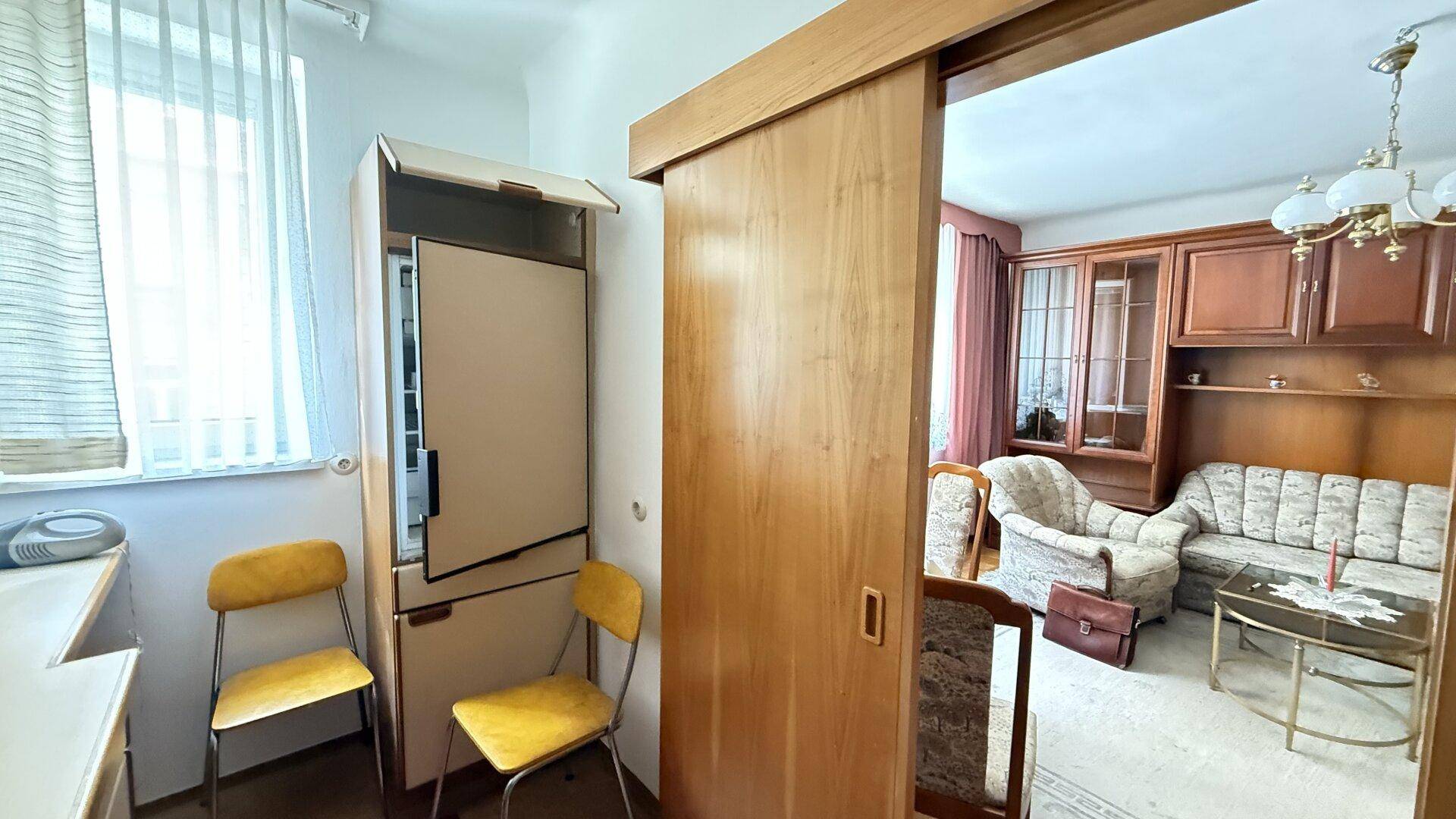 Kleine Küche mit Schiebetür zum Wohnzimmer und Fenster für natürliches Licht.