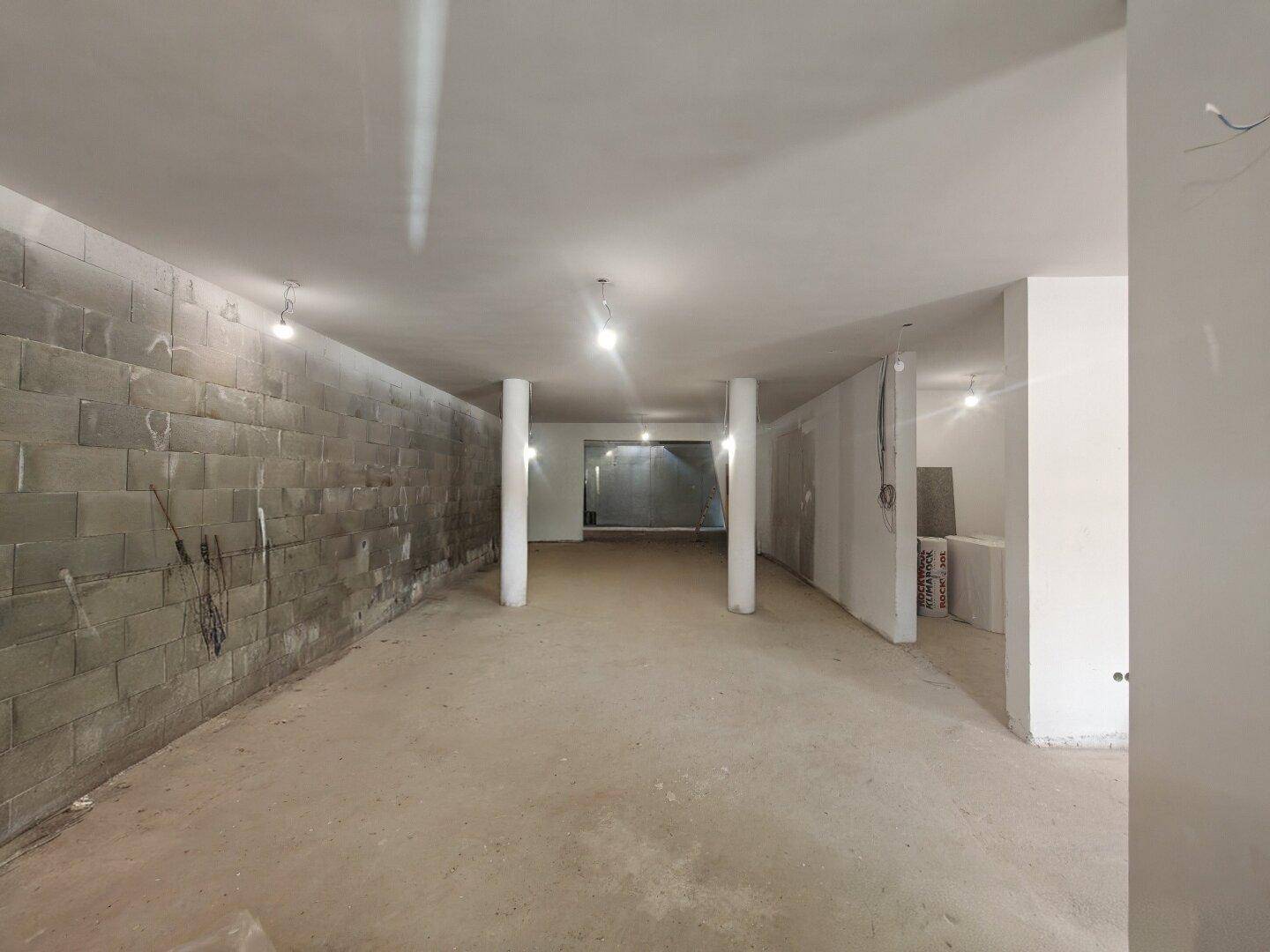Geräumiger Rohbau mit Betonwänden und -boden, ideal für individuelle Gestaltung und Nutzung.
