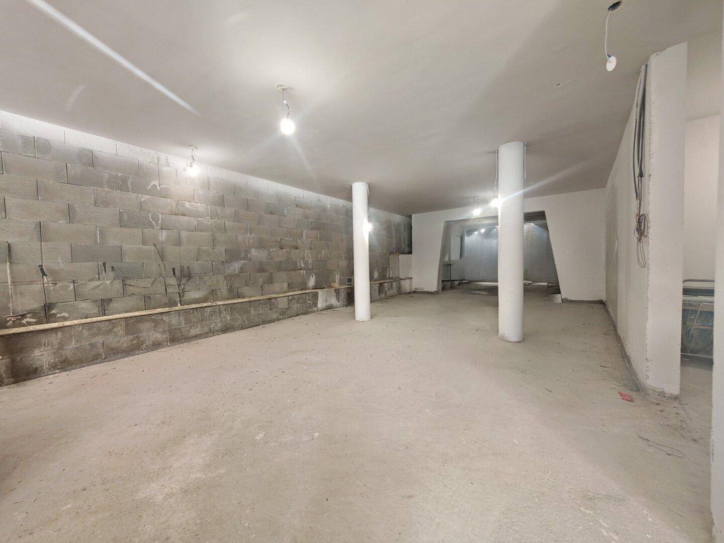 Weiterer Blick in den Rohbau mit massiven Betonwänden und tragenden Säulen.