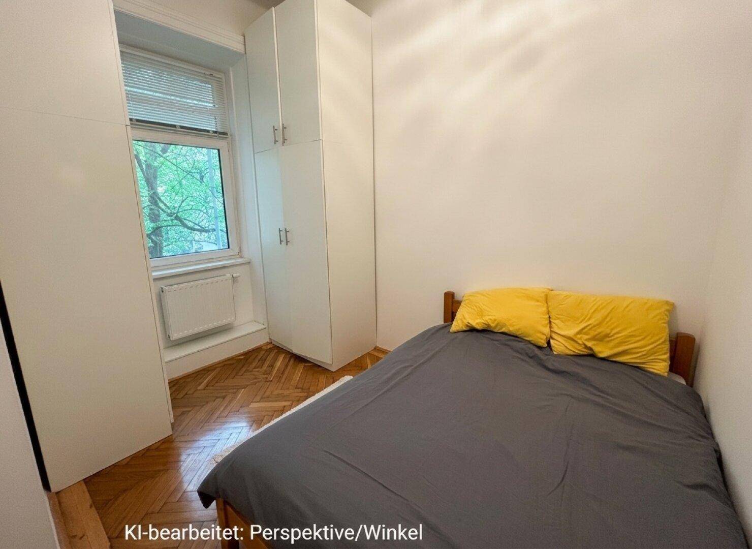 Schlafzimmer mit Fischgrätparkett, Einbauschränken und Blick ins Grüne durch das Fenster.