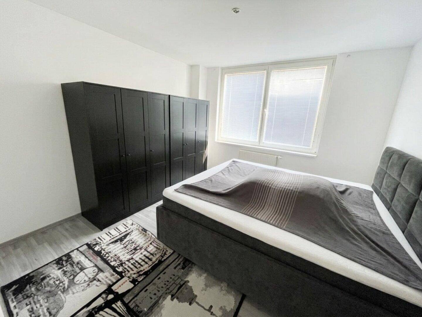 Geräumiges Schlafzimmer mit modernem Bett und großem Kleiderschrank.